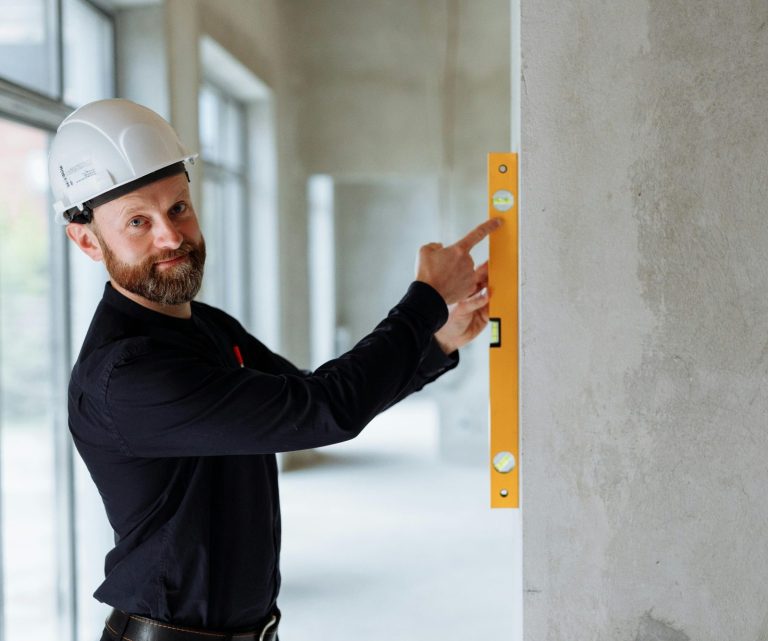 Handwerker prüft eine Wand mit der Wasserwaage